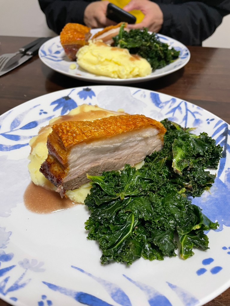 Cooked pork belly served with mash, gravy and greens. 